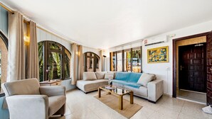 A living room with a sofa, armchairs, a coffee table, and large windows with curtains. - Holiday Home 'Brandy' with Sea View, Wi-Fi and Air Conditioning (Calpe)