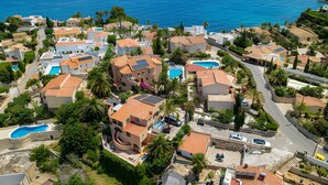 An aerial view of a coastal residential area with houses, swimming pools, and a clear view of the sea. - Holiday Home 'Brandy' with Sea View, Wi-Fi and Air Conditioning (Calpe)