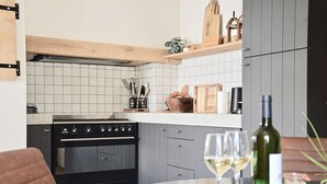 A kitchen with a stove, cabinets, and a countertop with various items.