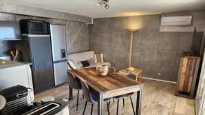 Een moderne keuken met een houten eettafel, een inbouwoven en een koelkast.