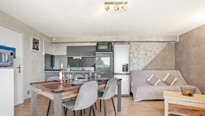 Een moderne keuken met een eethoek, een bank en een kleine tafel met een mandje.