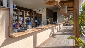 A bar area with shelves of bottles, a sign reading '1800 Tequila', and a wooden counter.