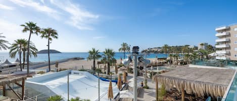 Un complexe hôtelier doté d’une piscine, d’une plage, de palmiers et offrant une vue sur la mer.