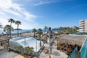 A resort with a pool, beach, palm trees, and a view of the sea. - First Line Cosy Apartment with Sea Views, Wi-Fi and Air Conditioning (Calvià)