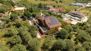 Un barrio residencial con varias casas, incluyendo una con techo de tejas rojas y paneles solares.