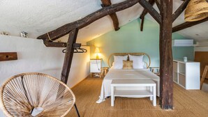 A bedroom with a bed, a chair, a nightstand, a lamp, and a ceiling with exposed beams. - Cottage 'La Caseta' with Shared Pool, Wi-Fi and Air Conditioning (Panjas)