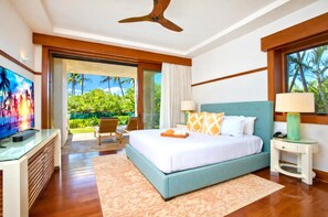 A bedroom with a bed, a TV, a ceiling fan, and a view of greenery. - Kapalua Bay Resort | Oceanfront 3 BR | Car Incl. w/ 6+ Nights | MON-2204 by KBM (Lahaina)