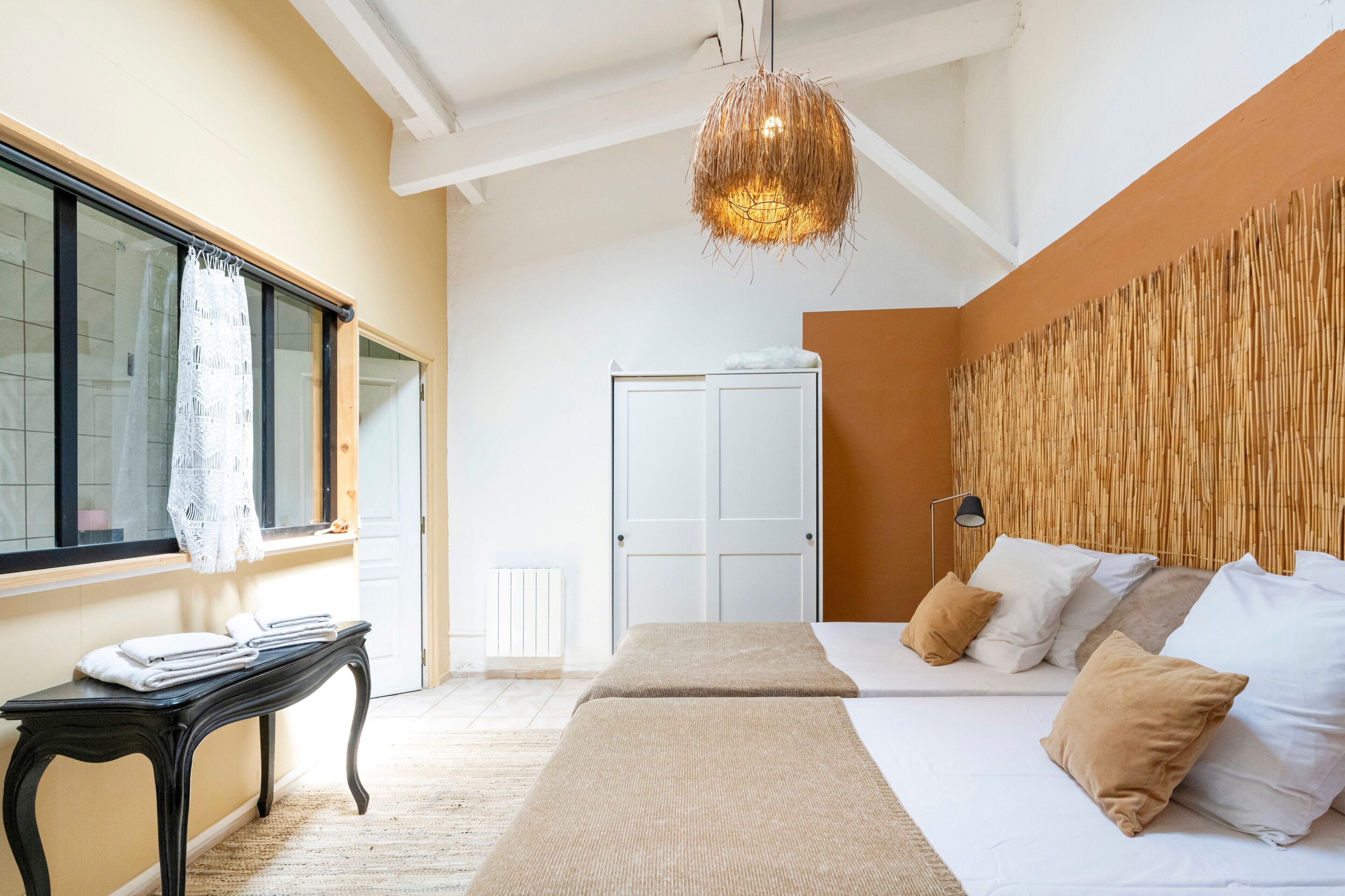 Une chambre à coucher avec un lit, une table de chevet et un luminaire suspendu.