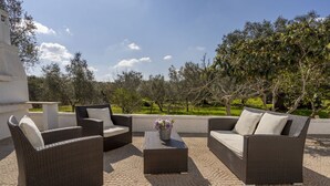 An outdoor seating area with wicker furniture and a central table.