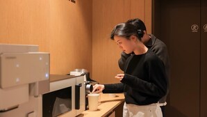 A person operating a coffee machine in a room with wooden walls and a sign that reads "CAGE". - Ace Hotel by Anook Daejeon Yuseong (Daejeon)