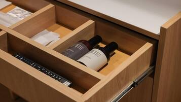 A wooden drawer with compartments, one of which contains two bottles and a keyboard.