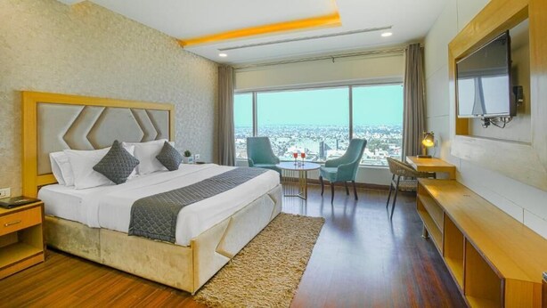 Ein modernes Hotelzimmer mit einem großen Bett, einem Schreibtisch und einem Fernseher.