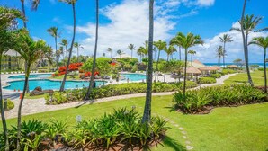 A resort with multiple swimming pools, palm trees, and a well-maintained lawn. - Lagoon View Resort Retreat (Lihue)