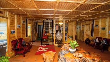Un interior de madera con una escalera central, zonas de estar y una chimenea.