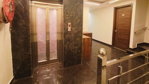 Un ascensor moderno con detalles metálicos y un panel decorativo.