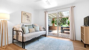 Un salon confortable avec un canapé, une lampe et un téléviseur.