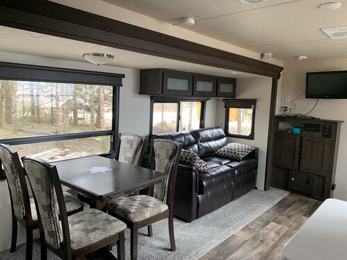 Modern RV camper with all the perks 
Nestled in tree at lake edge