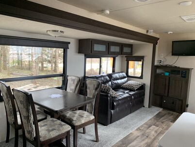 Modern RV camper with all the perks 
Nestled in tree at lake edge