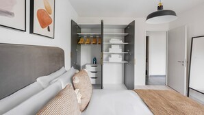 Ein modernes Schlafzimmer mit einem Bett, einem Kleiderschrank und einer Hängeleuchte.