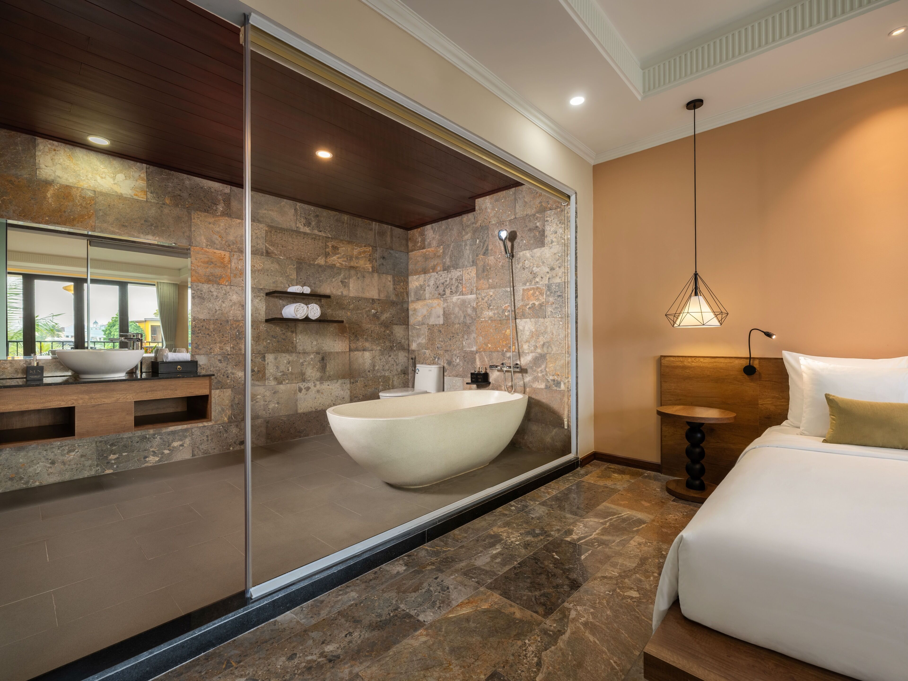 A modern bathroom with a large freestanding bathtub, a glass shower enclosure, and a wooden vanity with a mirror.