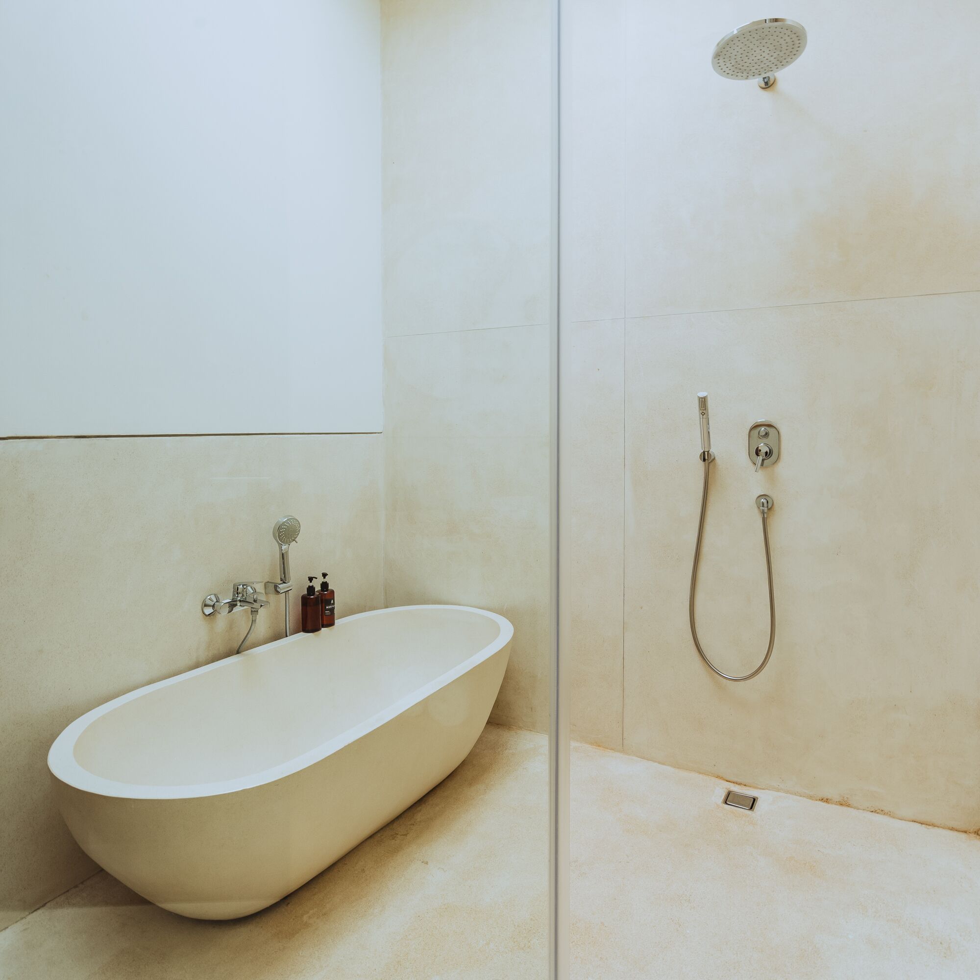 Ein modernes Badezimmer mit freistehender Badewanne, Duschbrause und Toilette.