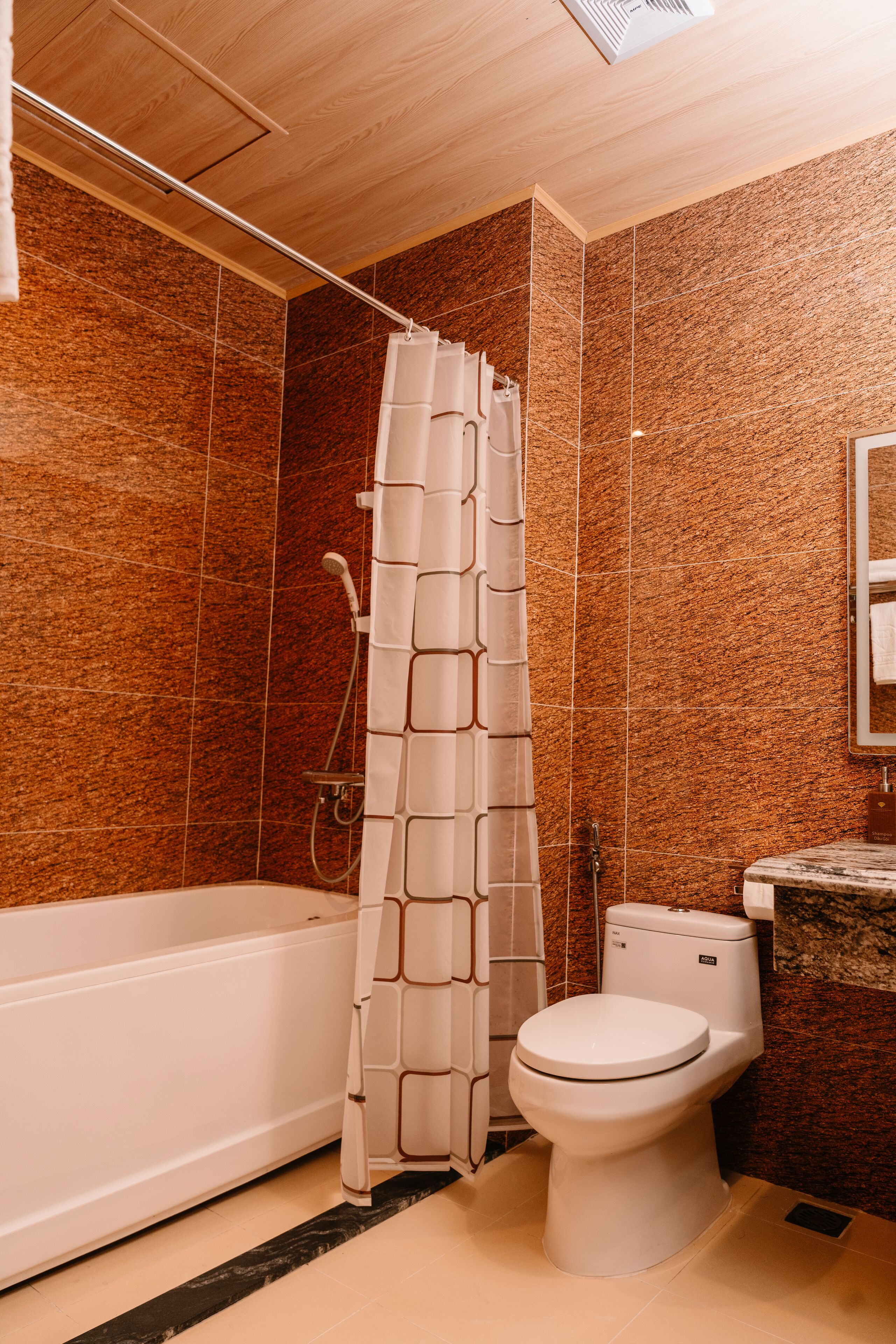 A bathroom with a shower curtain, a toilet, and a bathtub.