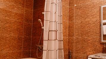 A bathroom with a shower curtain, a toilet, and a bathtub.