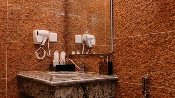 A modern bathroom with a granite countertop sink, a mirror, and a toilet.
