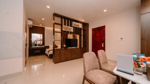 Una sala de estar moderna con un mueble de entretenimiento de madera, una puerta roja y un ordenador portátil sobre una mesa.