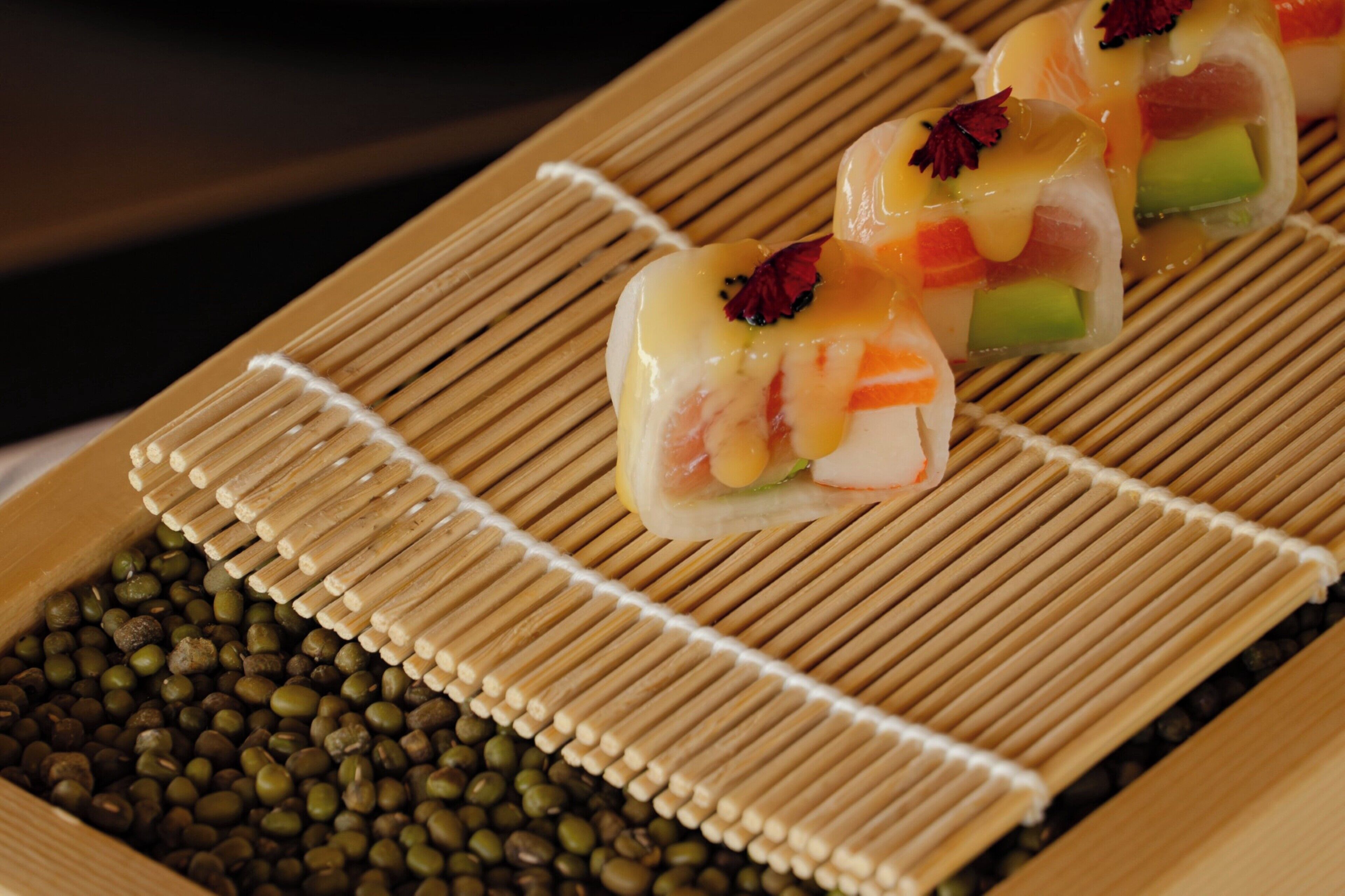 A sushi platter with various types of sushi on a bamboo mat.
