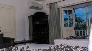 Une chambre d’hôtel avec un lit, une commode, une chaise et une fenêtre donnant sur l’extérieur.