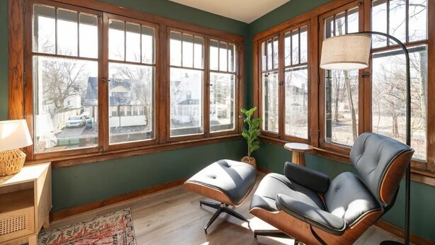A room with large windows, a chair, a lamp, and a small table. - Historic Craftsman, just 8 minutes from downtown Kalamazoo. (Kalamazoo)