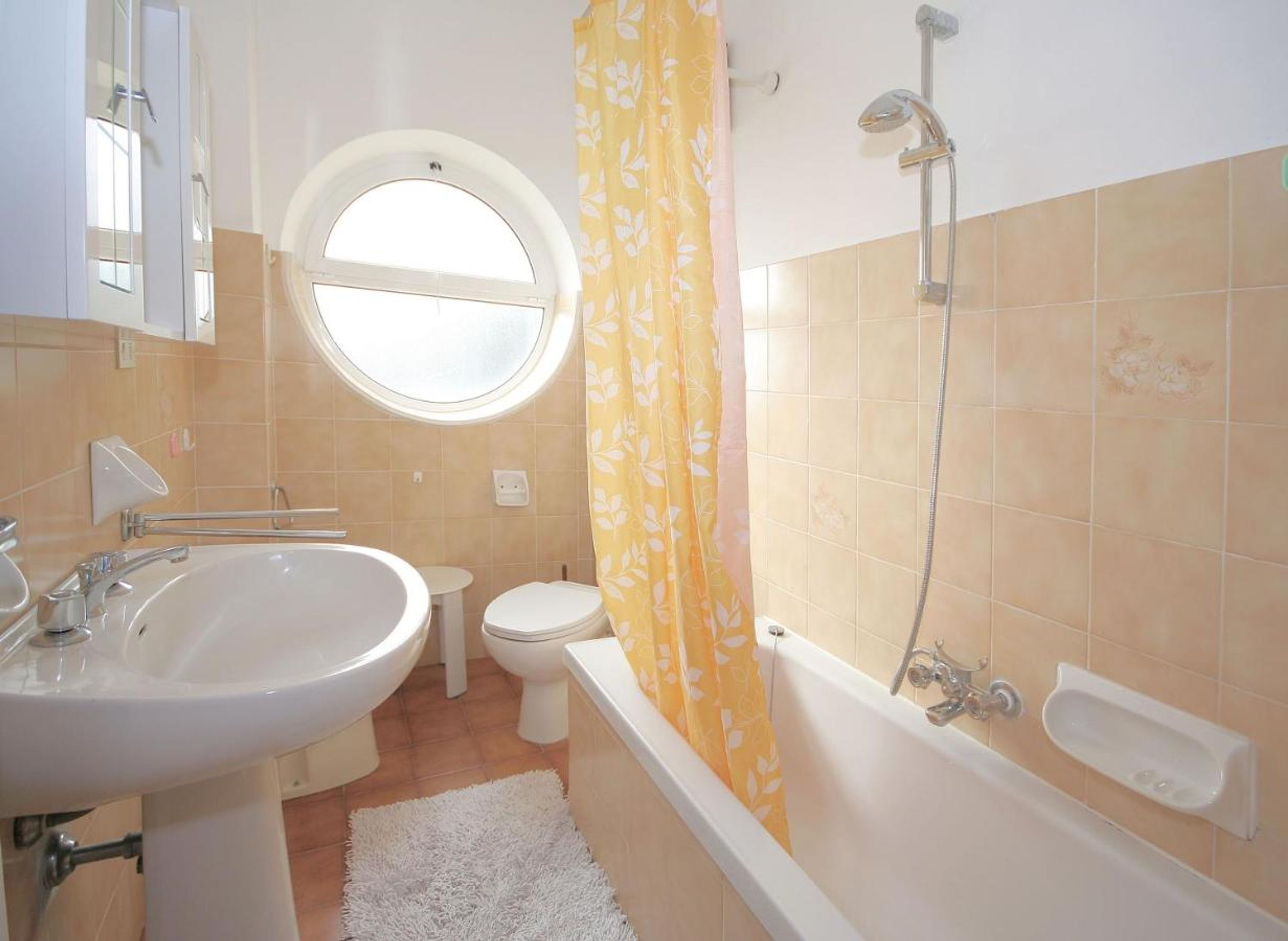A bathroom with a sink, toilet, and bathtub.