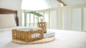 A neatly made bed with a white comforter and a wicker basket containing a white pillow and a book. - Ganghwa Nakjogaboineun spa Pension (Incheon)