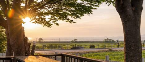 A wooden deck with a view of the ocean and a fence in the background.