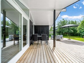 Relax on the outdoor patio with a dining table and comfortable seating under a spacious umbrella.