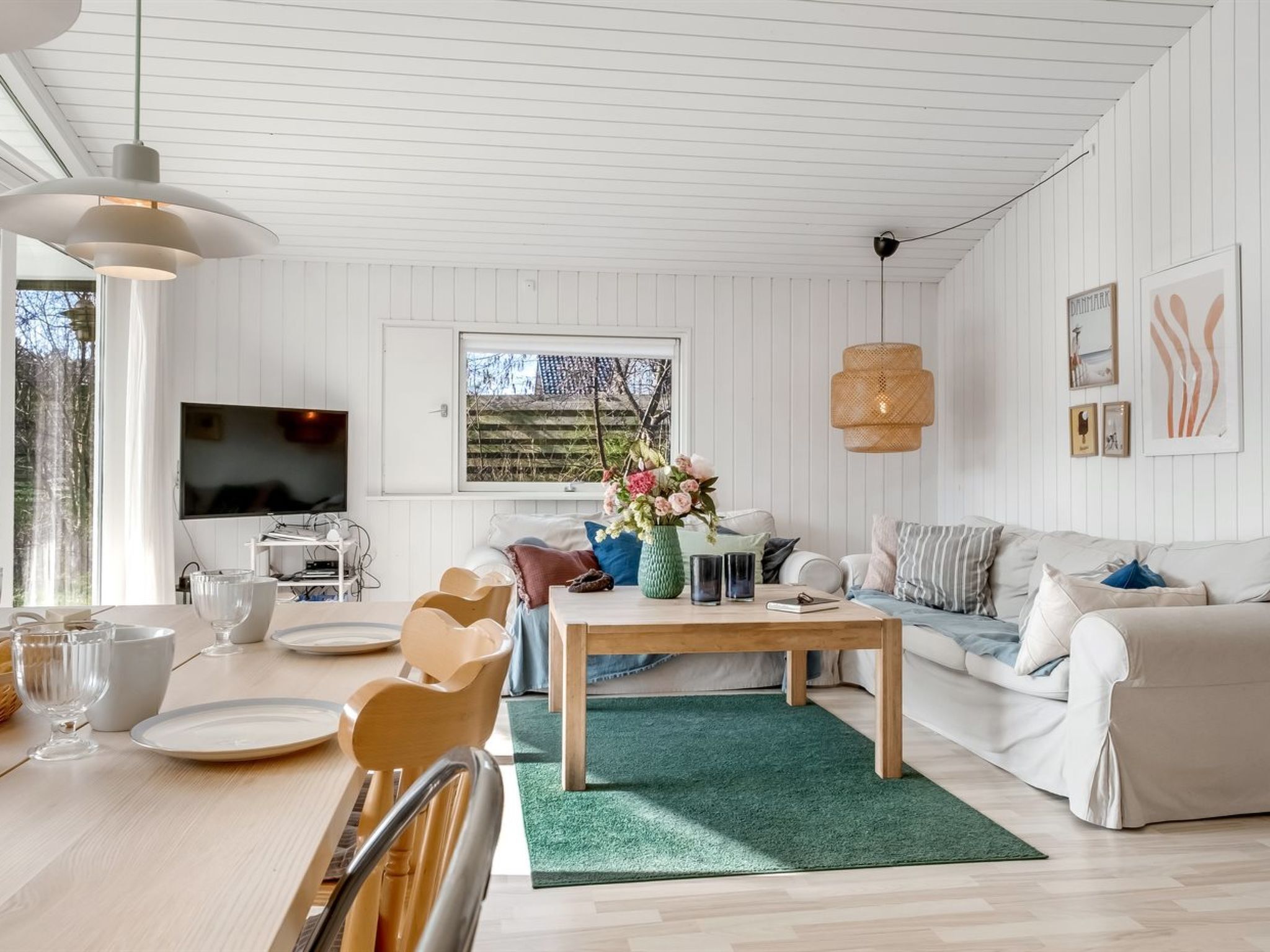 A modern living room with a wooden coffee table, sofa, and TV.