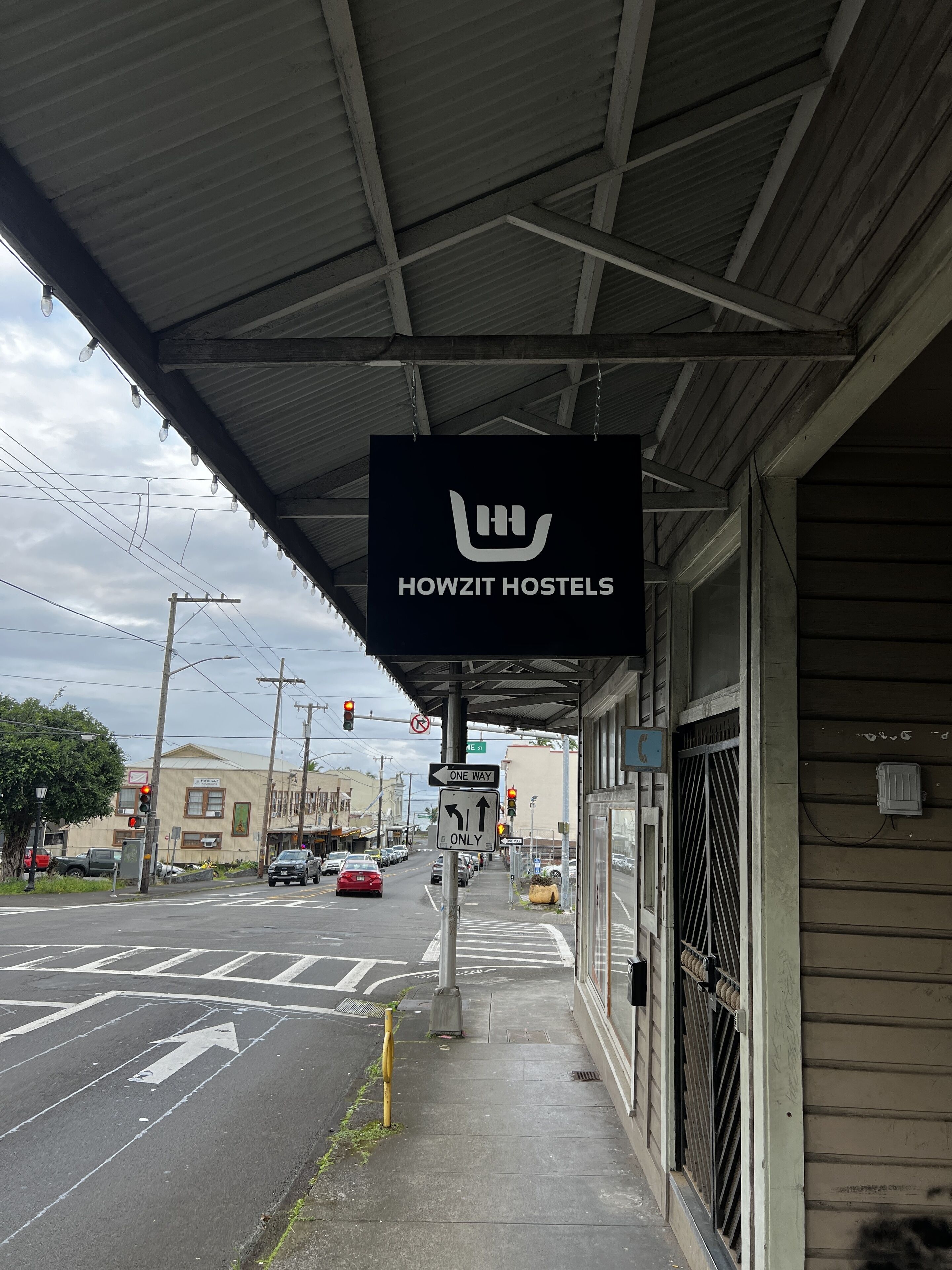 Et Howzit Hostels skilt, et fortabelseskilte og et lyskryds i et kryds.