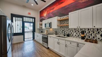A modern kitchen with white cabinets, a microwave, and a wooden countertop.
