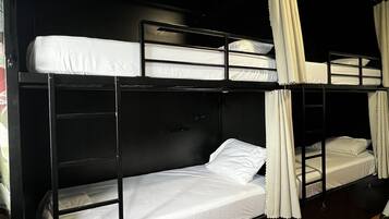 A bunk bed room with a wooden floor and black walls.