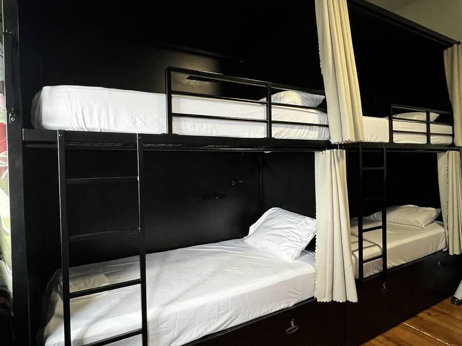 A bunk bed room with a wooden floor and black walls.