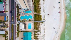 An aerial view of a coastal hotel with a swimming pool, beach access, and a parking area. - 135 Grande Island Blvd  - Dog Friendly (Panama City Beach)