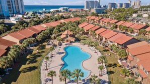 A resort with a central swimming pool, multiple guest buildings, and a view of the ocean. - 135 Grande Island Blvd  - Dog Friendly (Panama City Beach)