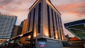 Een modern gebouw met een opvallend 'Yam'-bord, met een rechthoekige vorm, verticale ramen en een plat dak.