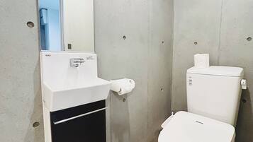 A bathroom with a white toilet, a sink with a mirror, and a checkered floor.