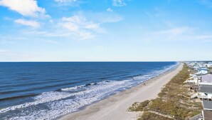 Una playa con una hilera de casas a lo largo de la costa.
