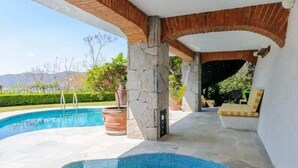 Un área de hidromasaje con pared de piedra, arco de ladrillo y piscina.
