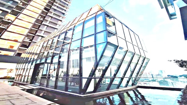 A modern glass building with a geometric design, situated by a body of water. - OYO Home 90948 Irishe Homestay Penang City Seaview (George Town)
