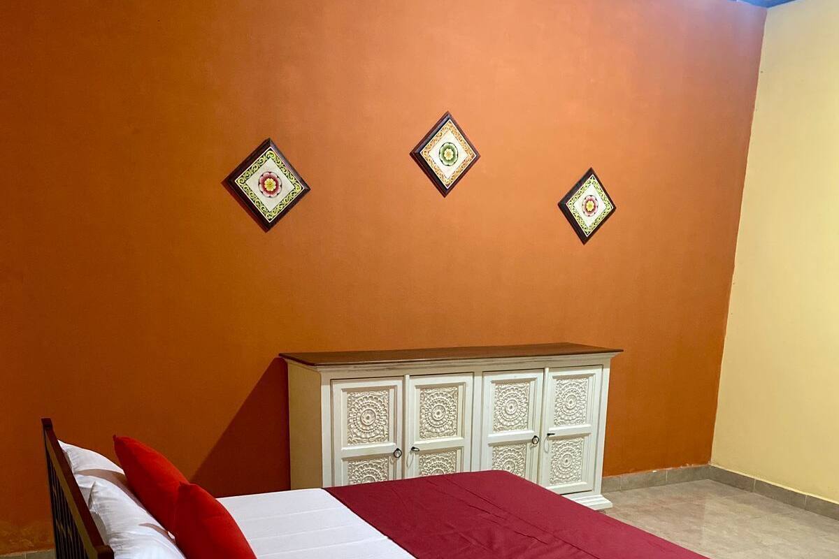 A bedroom with a bed, a nightstand, a wardrobe, and decorative wall panels.