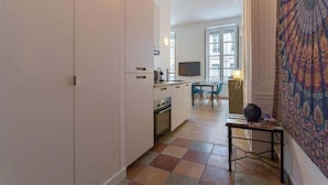 A modern kitchen with white cabinets, a dining area with a table and chairs, and a large window. - Patchwork - Furnished apartment - Downtown Lyon (Lyon)